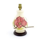 A Moorcroft table lamp decorated in the Pink Magnolia pattern. Approx. 10 1/2" high overall Please