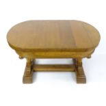 An early 20thC oak draw leaf dining table with an oval top with inlaid checkered frame and ball