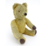 Toy: A 20thC mohair teddy bear with clockwork musical mechanism, stitched nose and mouth, pad paws