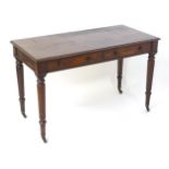An early 19thC mahogany two drawer writing desk, having a moulded top above two short drawers with
