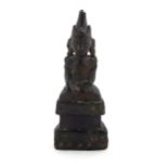 An Asian carved wooden seated deity with lacquered detail. Approx. 8 3/4" high Please Note - we do