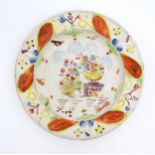 A 19thC plate decorated in Pratt colours depicting flowers and foliage. Approx. 8 3/4" diameter