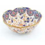 A Chinese bowl with a scalloped edge decorated with scrolling floral and foliate detail. Character