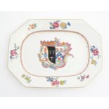 A Chinese export style serving plate with hand painted armorial detail, depicting a coat of arms