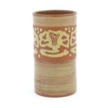 A terracotta studio pottery vase of cylindrical form with banded slip decoration. Signed under.