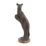 A 20thC Continental cast patinated bronze model of a leopard / big cat on a styled tree stump. On