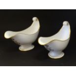 A pair of large French Dore a Sevres sauce boats with scroll handles, decorated with gilt crowned