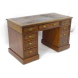 A late 19thC walnut double pedestal desk, the desk having a gold tooled leather top above one drawer