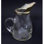 A glass jug with loop handle and silver plate mounts. Approx 7 1/2" high Please Note - we do not