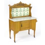 A late 19thC / early 20thC marble topped washstand with a tiled backsplash and Art Nouveau style