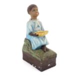 A 20thC Continental polychromed composite collection box / mission money box modelled as a seated