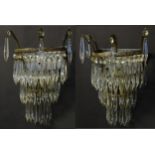 A pair of three tier wall lights with lustre drops and floral and foliate gilt metal detail. Approx.