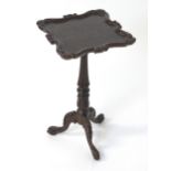 A Victorian oak wine table in the manner of Gillows with a carved top above a fluted tapering base