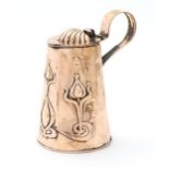 An Art Nouveau copper lidded jug of tapering form with loop handle and relief stylised floral