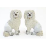 A pair of Staffordshire pottery models of seated Poodle dogs with gilded collars. Approx. 5 1/2"