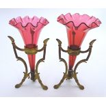 A pair of Victorian epergnes with cranberry glass flutes supported within a gilt brass base with