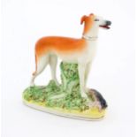 A 19thC flatback Staffordshire pottery model of a greyhound holding a rabbit in its mouth. Approx.