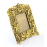 A late 19th / early 20thC Continental easel back photograph frame with cast and gilded surround