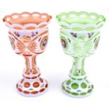 Two Bohemian glass pedestal vases in peach and pale green with white overlay and floral