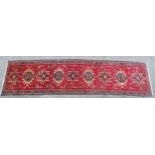 Carpet / rug : A Heriz runner, the red ground decoration with various geometric medallions, with