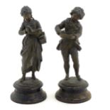 A pair of 20thC cast figures depicting 19thC children, one a girl reading a book, the other a boy