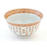 A small Chinese red and white bowl decorated with flowers and foliage, the exterior with character