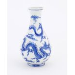 A Chinese blue and white vase decorated with three dragons amongst stylised clouds. Approx. 9"