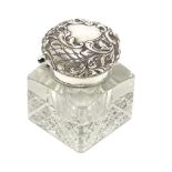 A cut glass inkwell of squared form with an embossed silver lid hallmarked London 1901, maker W &