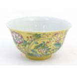 A Chinese famille rose small bowl with a gilt ground decorated with flowers and foliage. Character
