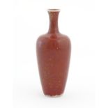 A Chinese vase of tapering baluster form with a red glaze. Character marks under. Approx. 8" high