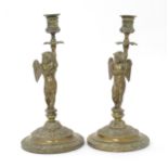 A pair of Victorian brass candlesticks, the columns modelled as putti / cherubs supporting the