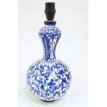 A ceramic table lamp of baluster form decorated with blue and white foliate scroll detail. Approx