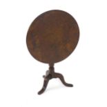 A George III tilt top table with a solid burr top above a turned pedestal base and three