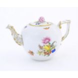 A Herend pottery teapot decorated in the pattern Fruits & Flowers, with gilt highlights and a rose