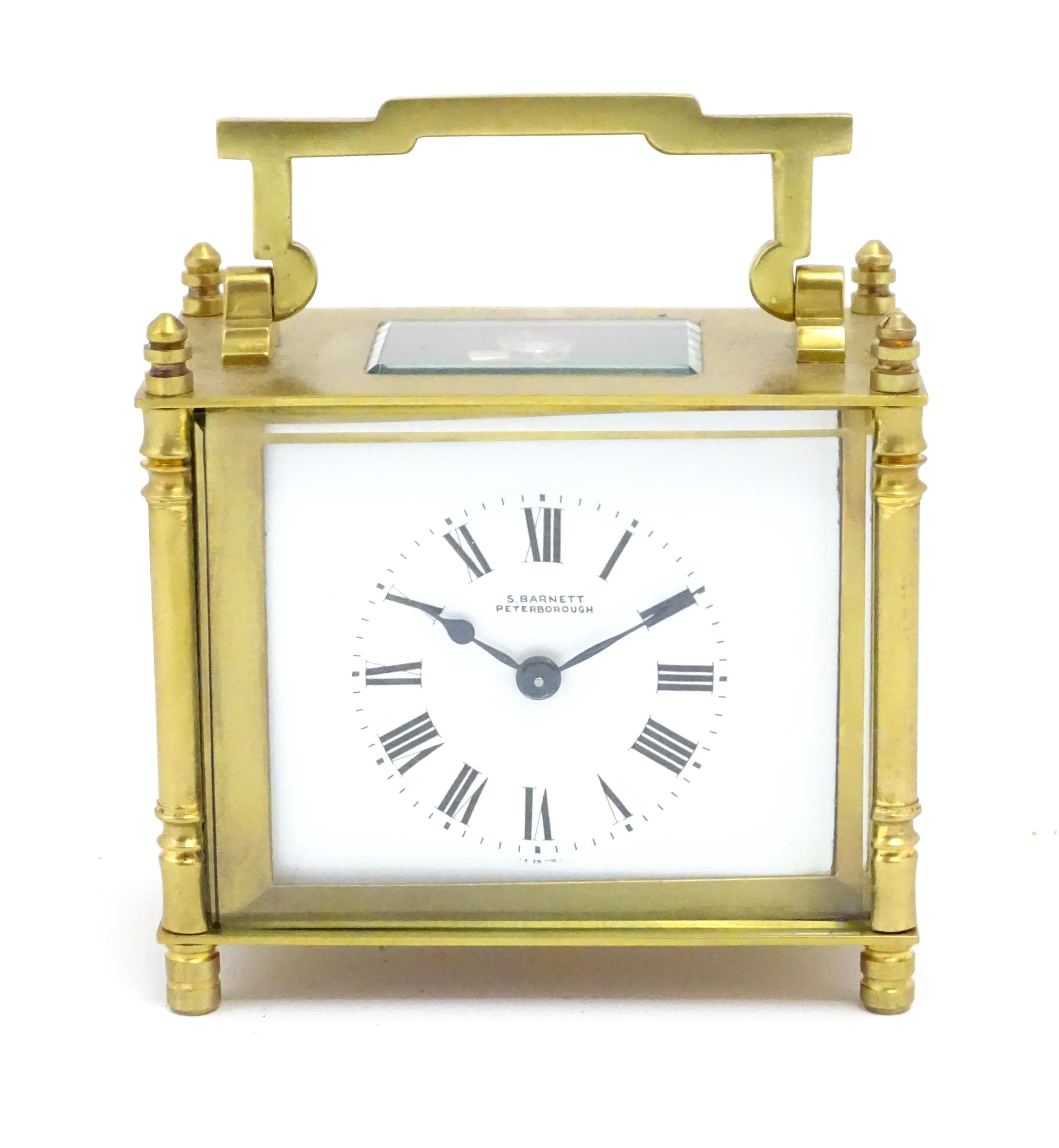 A French brass cased carriage clock with white enamel dial signed ' S Barnett Peterborough ' the