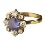 Ring. An 18ct gold sapphire and diamond cluster ring