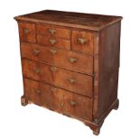 AN EARLY GEORGE II WALNUT AND OAK CHEST OF DRAWERS