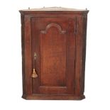 A GEORGE III OAK HANGING CORNER CUPBOARD