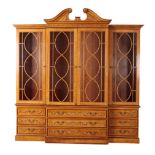 A GEORGE III STYLE STAINED WOOD AND POLYCHROME BREAKFRONT BOOKCASE