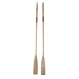 A PAIR OF TALL WOOD AND LEATHER BANDED OARS