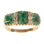 A THREE STONE EMERALD AND DIAMOND RING