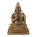 A SINO-TIBETAN BRONZE FIGURE OF A SEATED LAMA