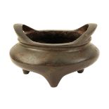 A CHINESE BRONZE TWO-HANDLED TRIPOD CENSER