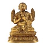 A SMALL SINO-TIBETAN GILT BRONZE OF A BUDDHIST MONK