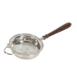 AN ELIZABETH II SILVER TEA STRAINER