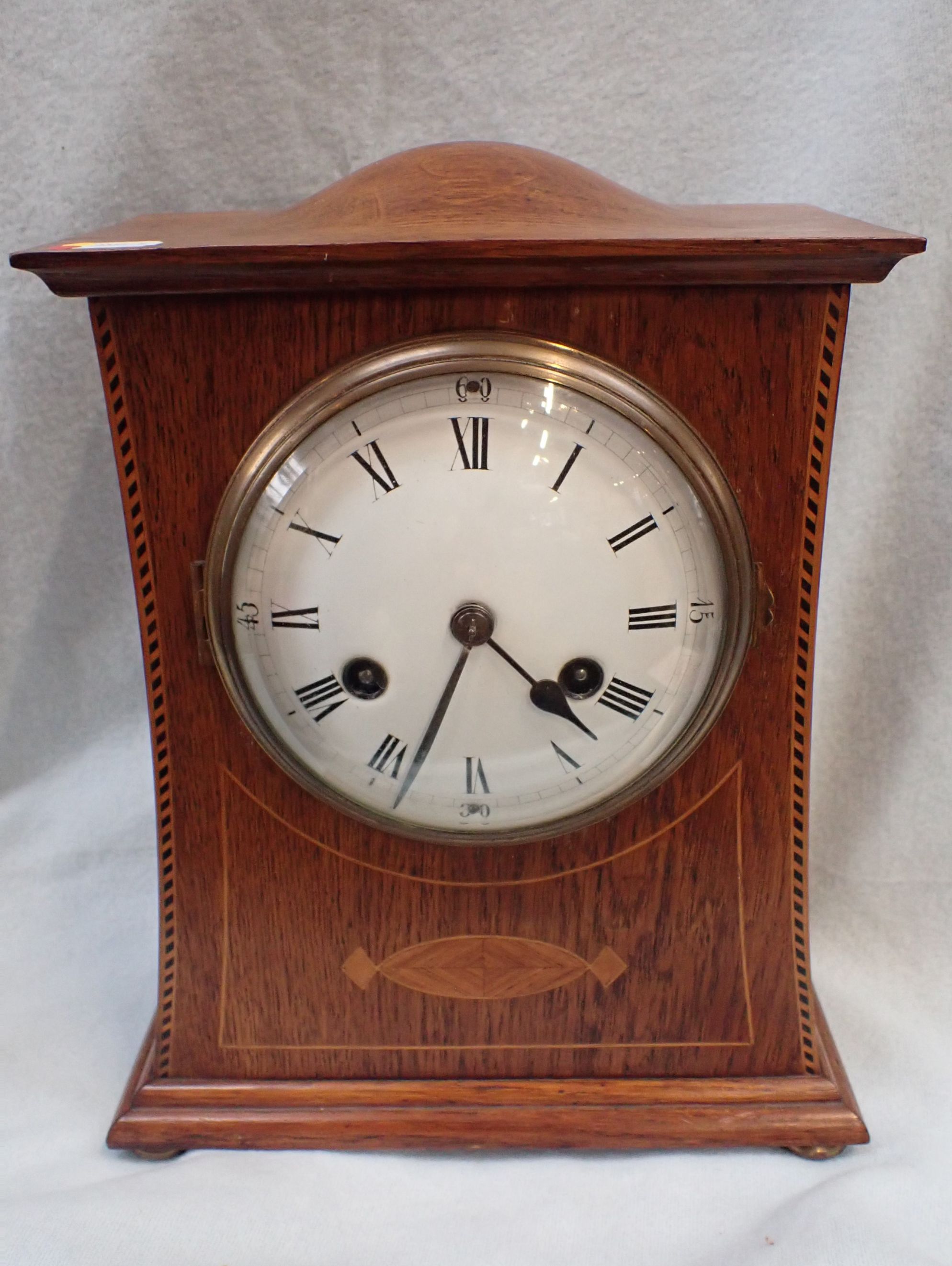 AN EDWARDIAN OAK-CASED AND INLAID MANTEL CLOCK