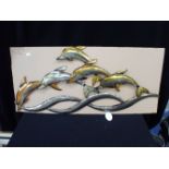 A METAL WALL ART PIECE DEPICTING DOLPHINS