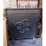 A WROUGHT-IRON AND MESH FIRE SCREEN AND A BRASS POKER