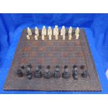 A 19th CENTURY CARVED OAK CHESS BOARD