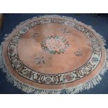 A PEACH GROUND OVAL CHINESE RUG